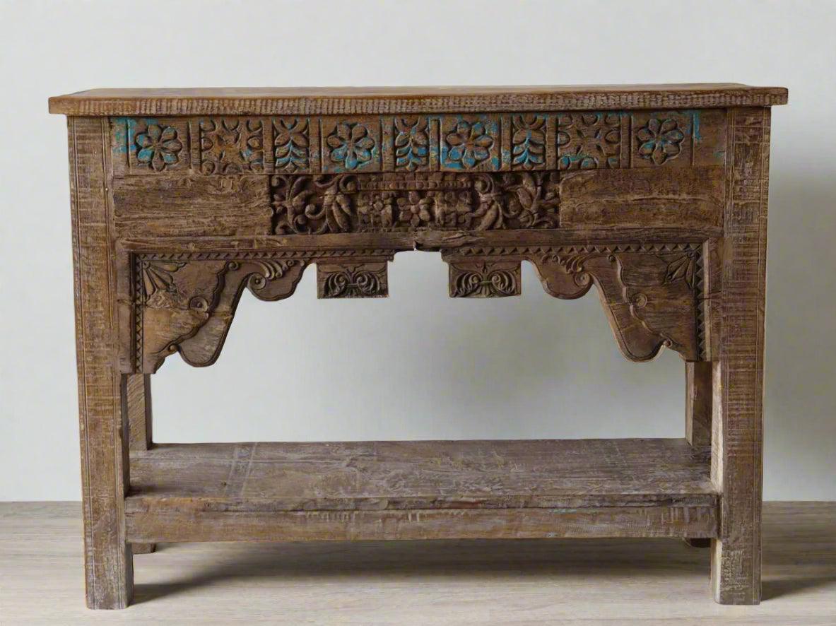 Wooden console table with intricate carvings on a plain background