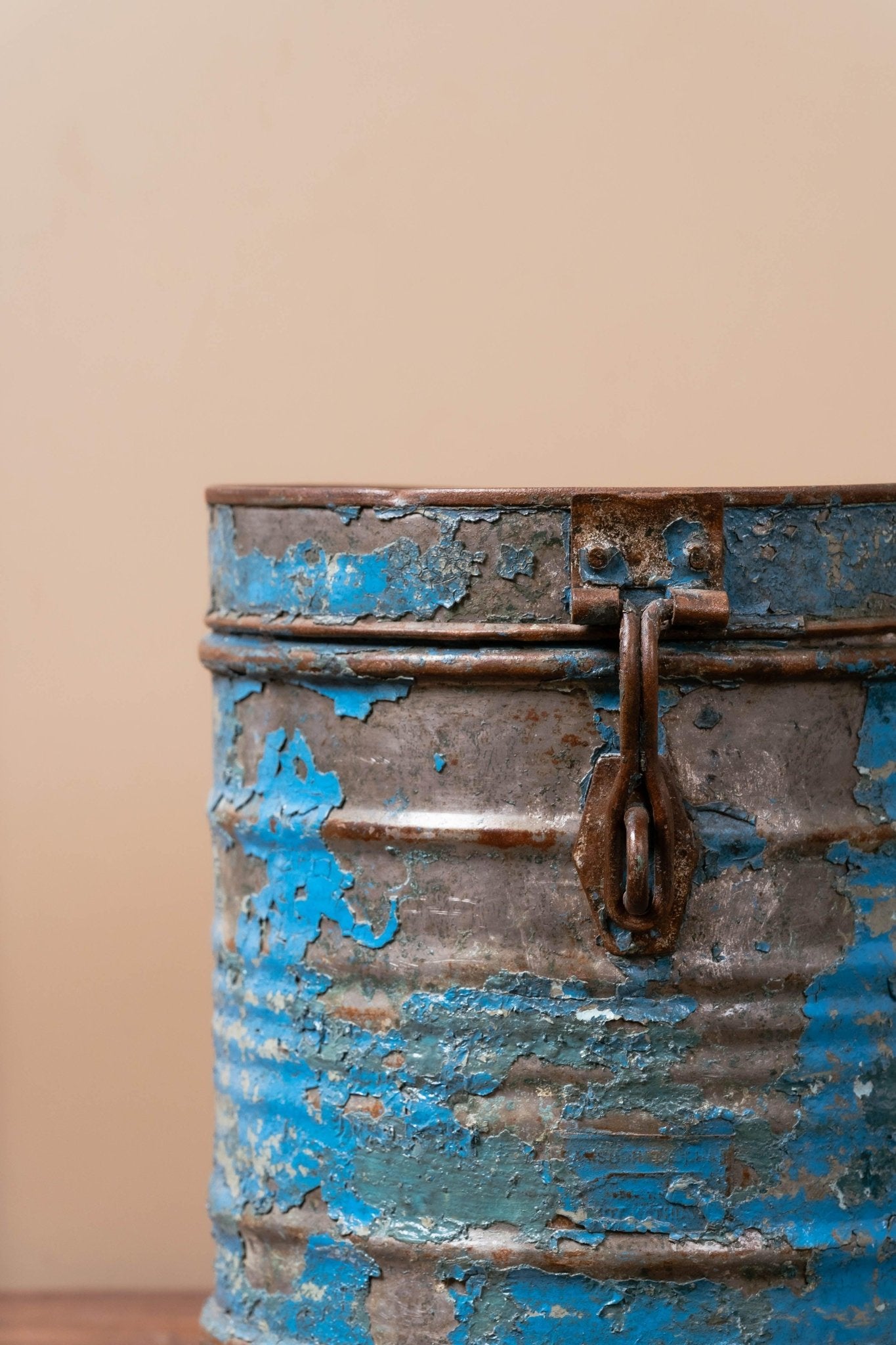 Side view of refurbished blue iron storage canister with smooth rounded edges and antique charm