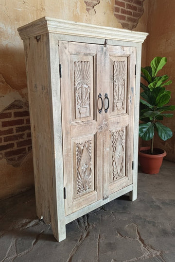 Wooden cabinet with carvings on a stone floor