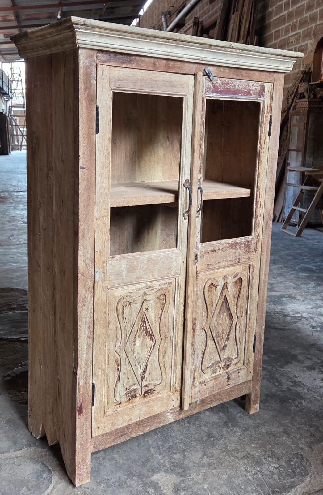 Vintage wooden cabinet with carvings in a workshop setting