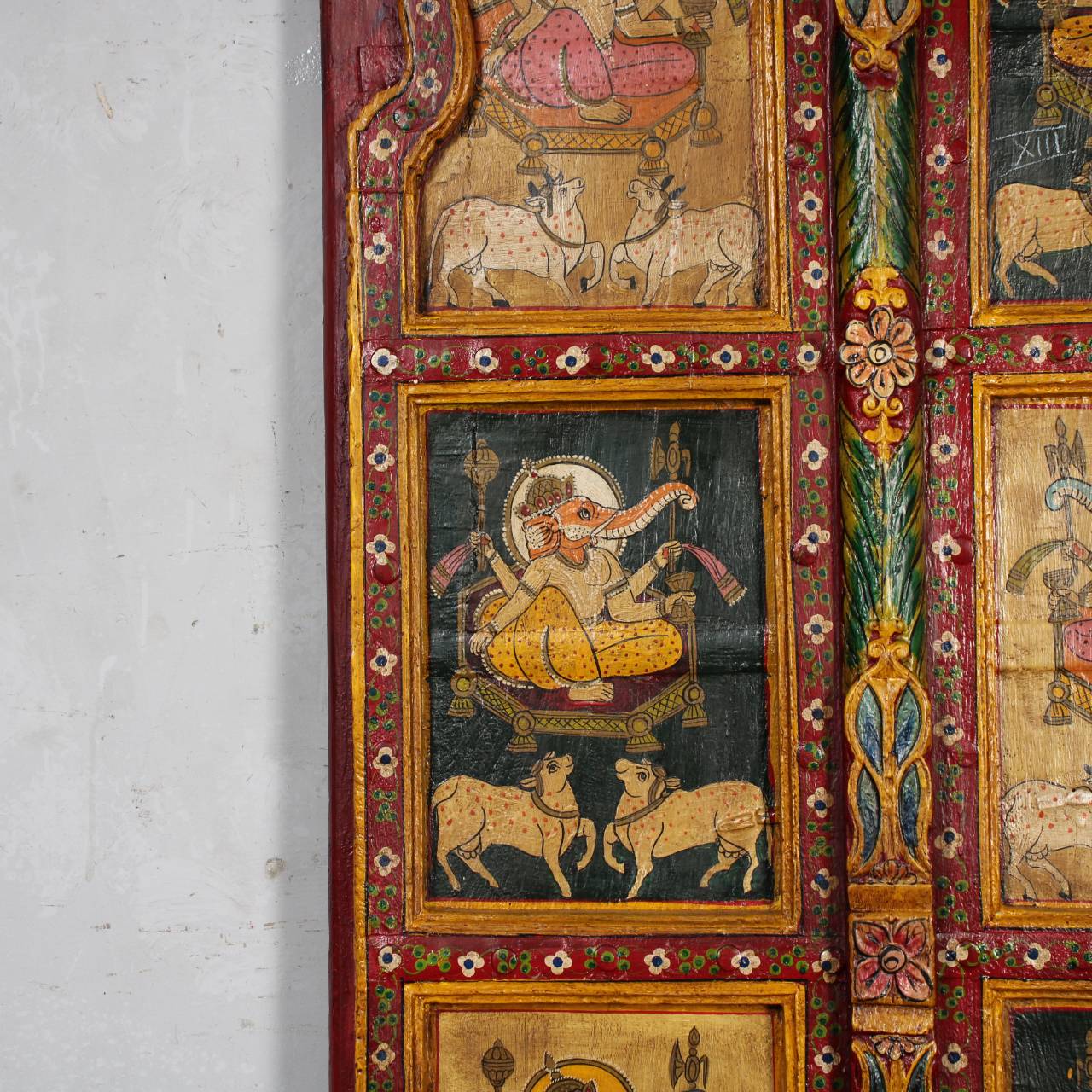 Decorative panel with intricate artwork and colorful borders on a white wall.