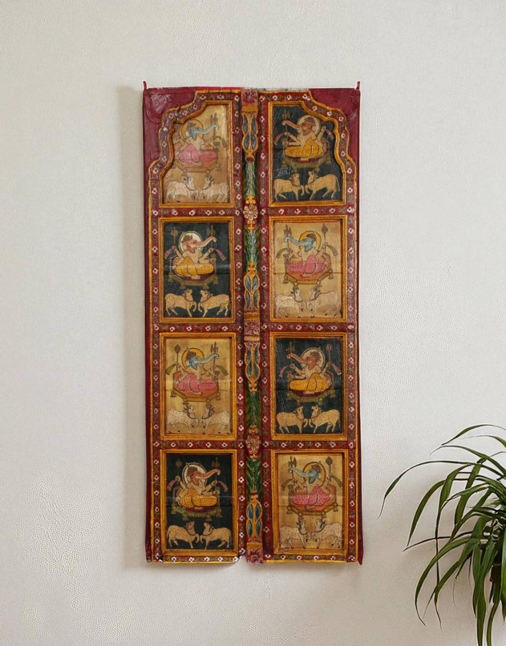 Decorative wall hanging with colorful illustrations on a white wall.