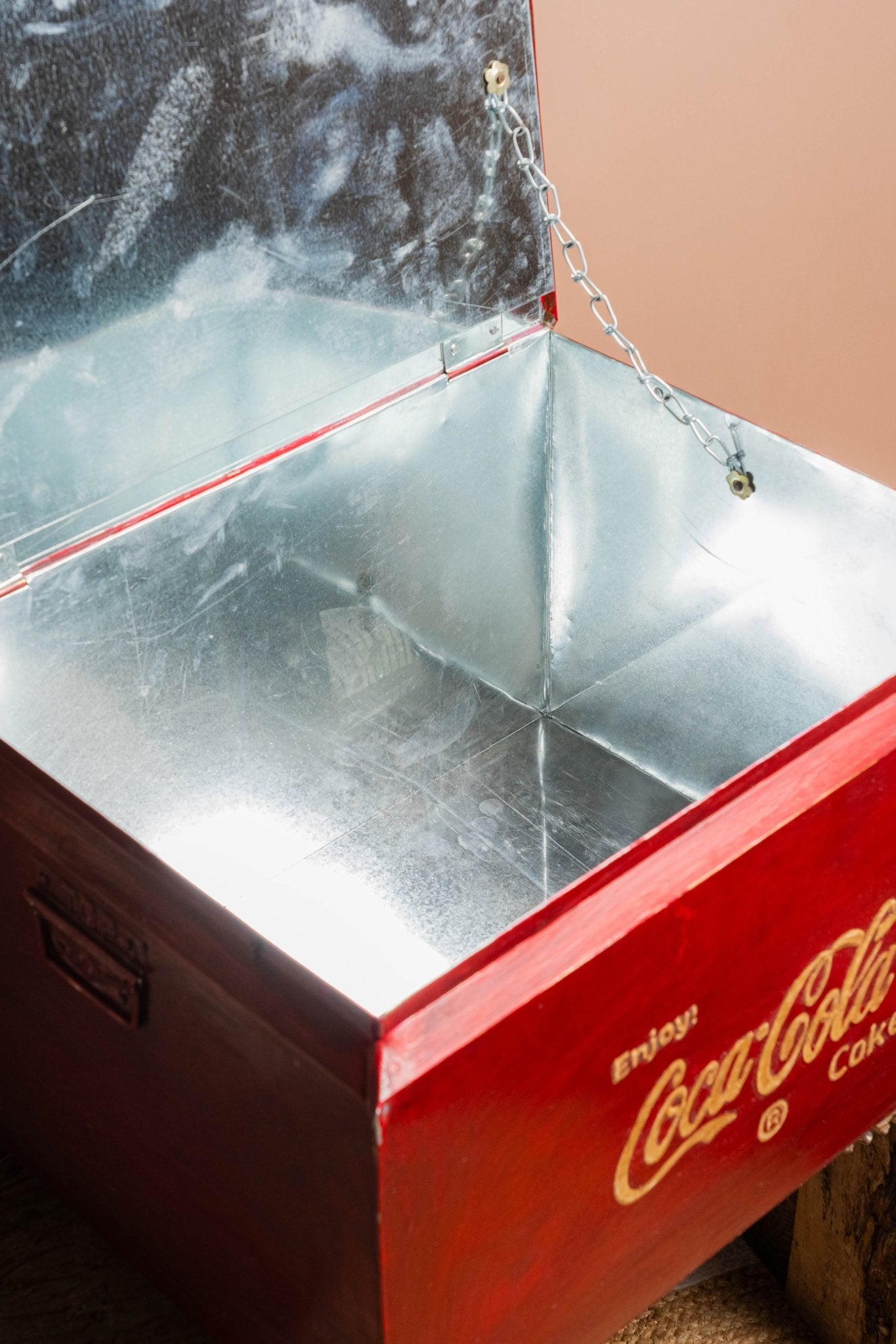 Metal cooler with Coca-Cola logo on a textured surface