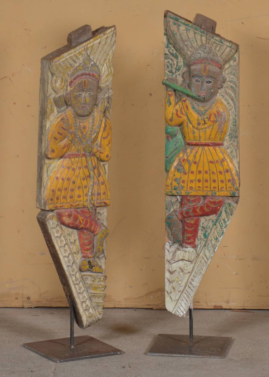 decorative panels with figurative designs on stands against a beige wall.