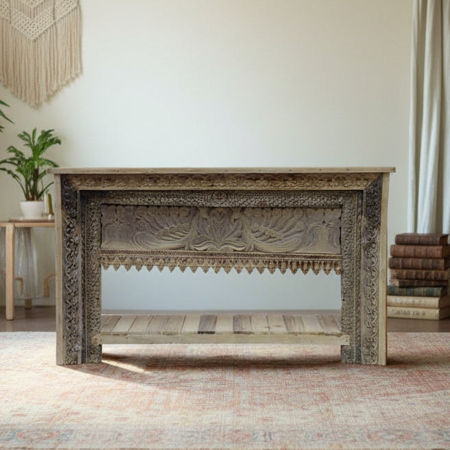 Decorative wooden console table with intricate carvings in a room setting.