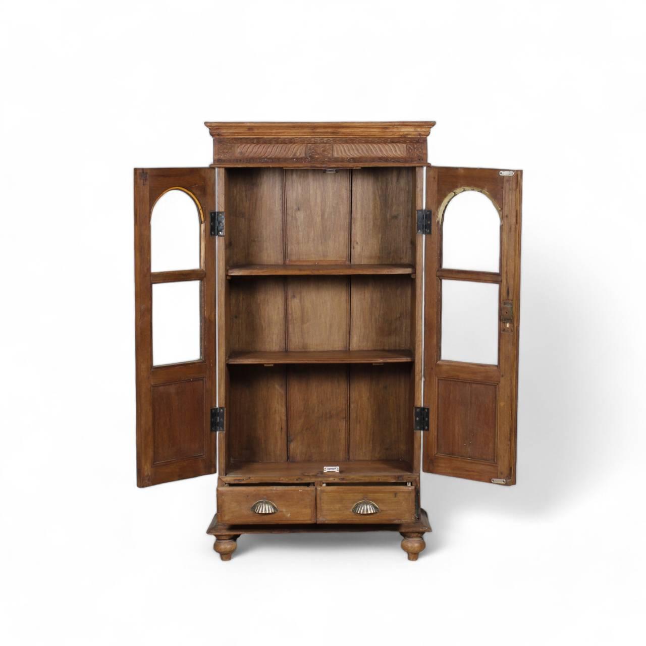 Side view of vintage glass almirah displaying brass hardware details and natural teak wood grain finish