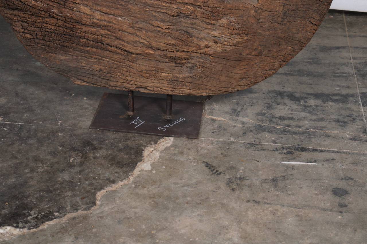 Round wooden object on a dark concrete floor