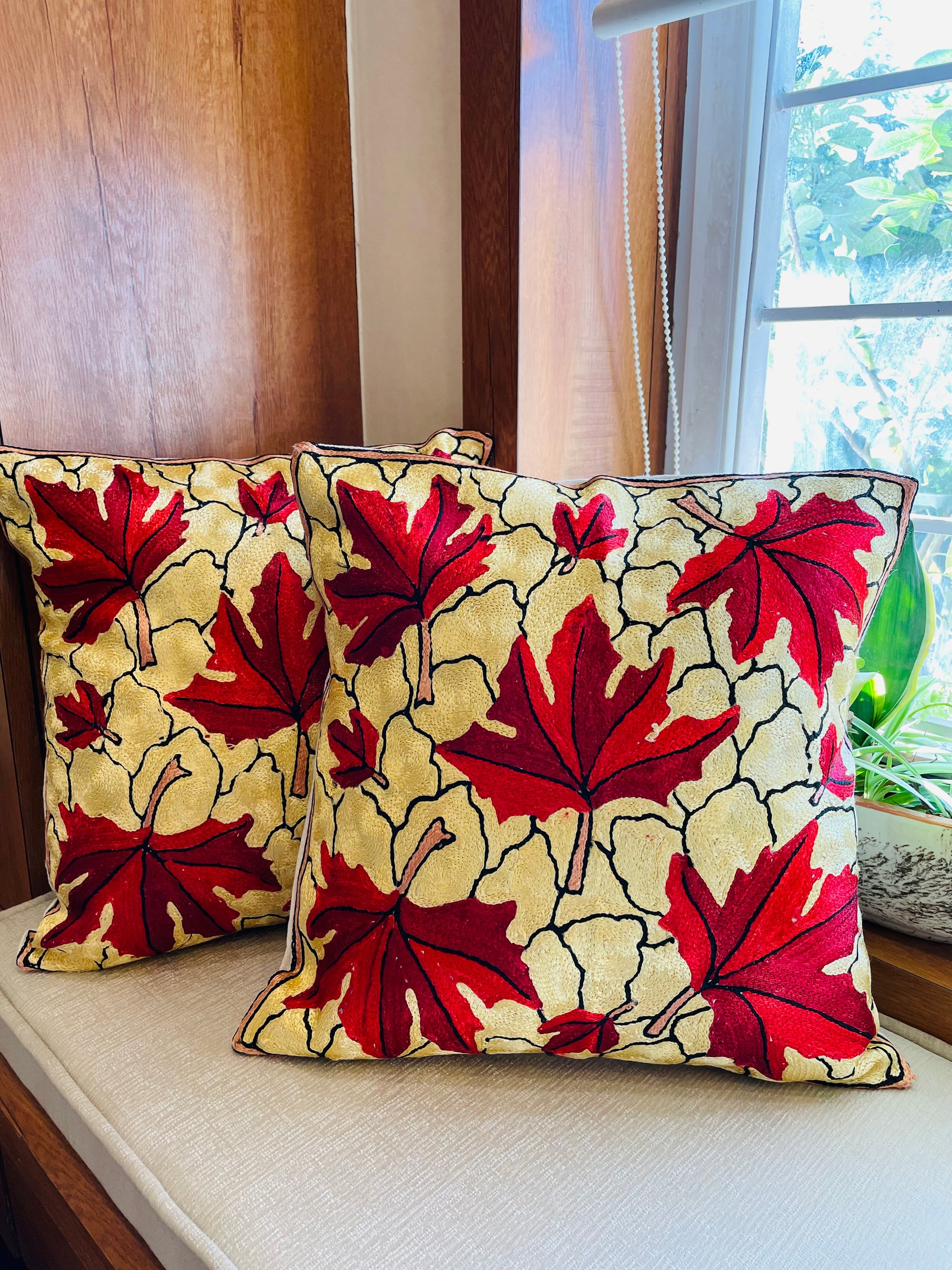 Maple leaf embroidered cushion cover Chainstitch embroidery Handcrafted home decor Kashmiri artisans Mill dyed cotton fabric Silk thread embroidery Colorful floral motif Elegant cream design Cozy home accents Unique cushion cover Interior design trend Decorative throw pillow Handmade craftsmanship Home decor gift idea Cushion insert not included