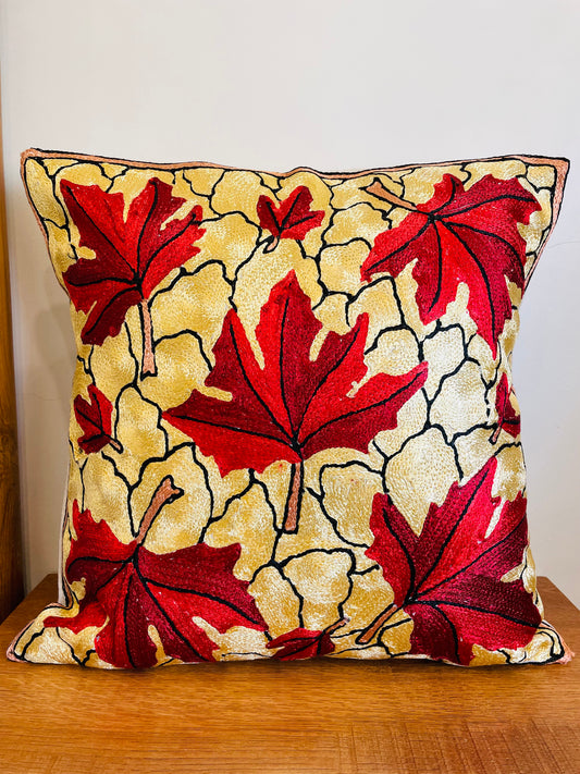 Maple leaf embroidered cushion cover Chainstitch embroidery Handcrafted home decor Kashmiri artisans Mill dyed cotton fabric Silk thread embroidery Colorful floral motif Elegant cream design Cozy home accents Unique cushion cover Interior design trend Decorative throw pillow Handmade craftsmanship Home decor gift idea Cushion insert not included
