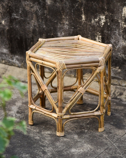 Hexagonal rattan stool against a textured wall
