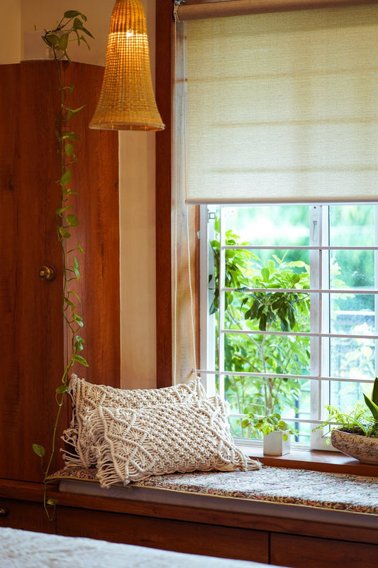 Handwoven macramé cushion cover with intricate knotted detailing and a soft bohemian texture.