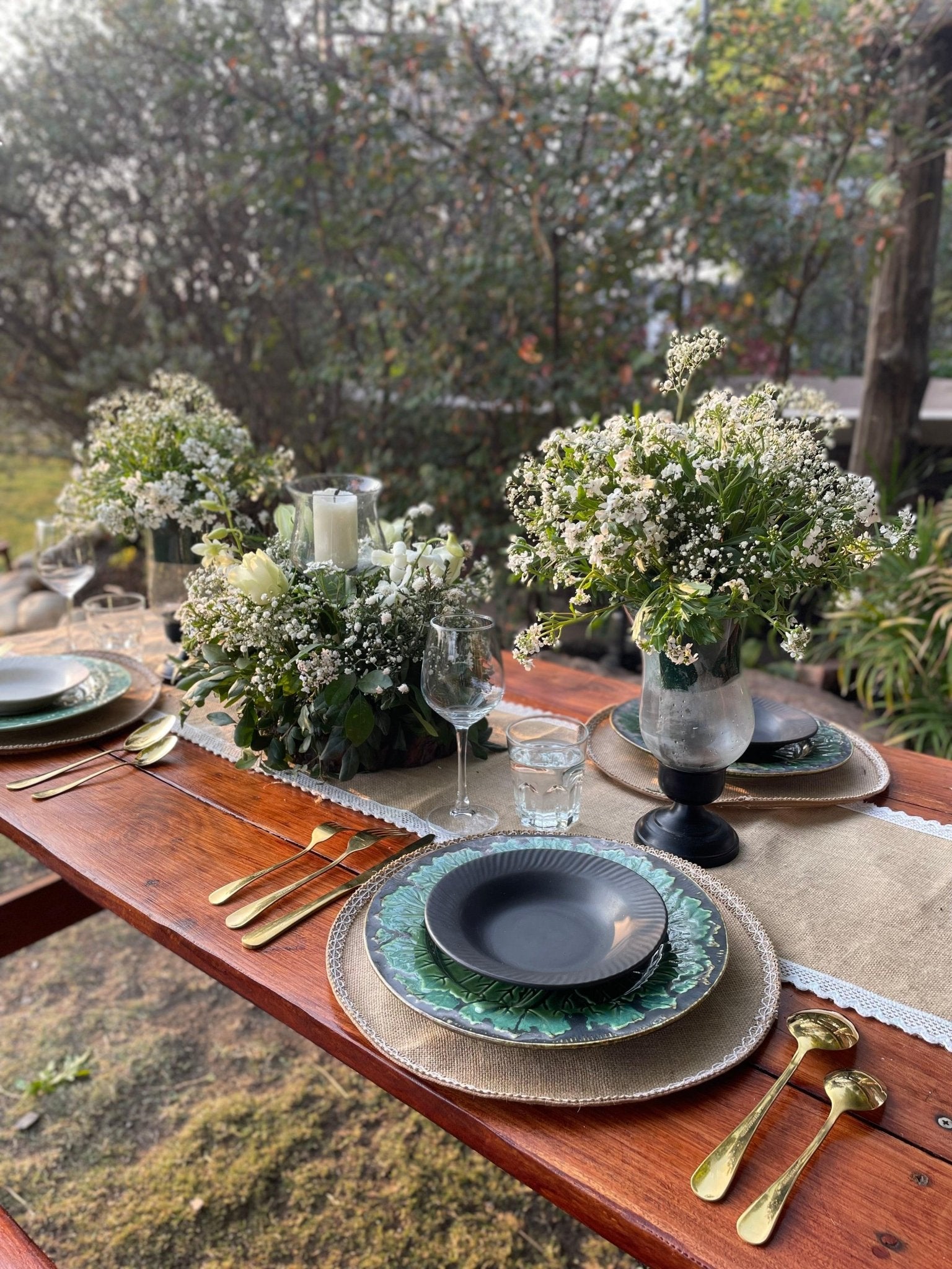 Elegant outdoor table setting with floral arrangements and decorative plates.