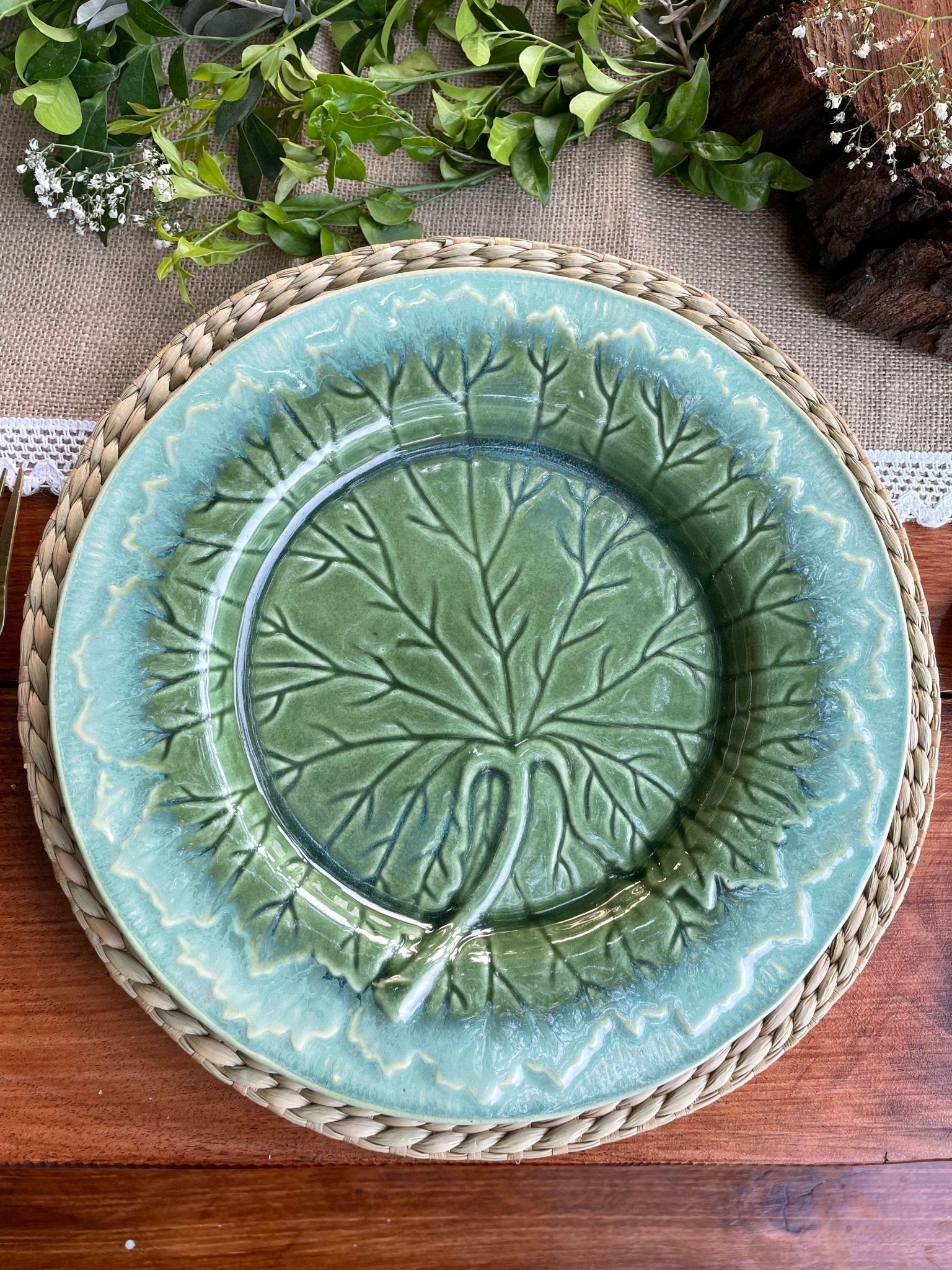 Green ceramic plate with leaf design on a woven placemat